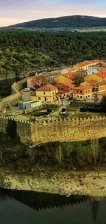 Scenic aerial view of a hilltop castle with surrounding greenery and water.