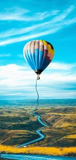 Vibrant hot air balloon over scenic landscape.