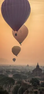 Hot air balloons float over an ancient city at sunset.