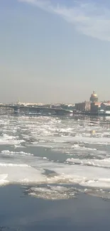 Serene icy river with distant city skyline.