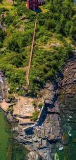 Aerial view of a green island with red lighthouse.