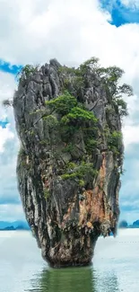 Vertical island rock with greenery and sky.