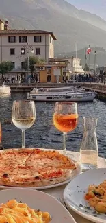 Italian dining view with pizza, pasta, and wine by the waterfront.