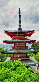 Traditional Japanese pagoda with lush greenery and cloudy sky background.