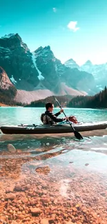 Kayaker on a serene lake with majestic mountains and clear blue skies.