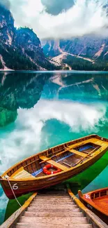 Wooden boat on tranquil lake with scenic mountains.