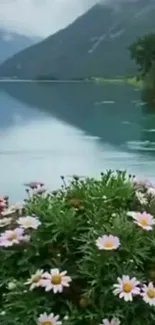 Serene lake with mountains and vibrant flowers in foreground.