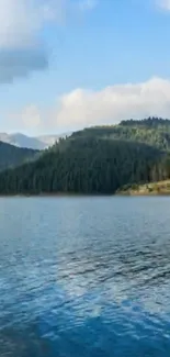 Scenic lake with mountain backdrop under a bright blue sky.