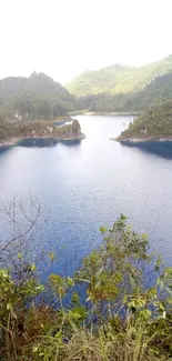 Serene lake with lush green mountains and blue waters.