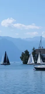 Serene lake scene with sailboats and distant mountains under a clear blue sky.