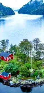 Red house by the lake with lush green trees and picturesque water view.