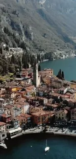 Aerial view of a colorful village by a serene lake with mountains in the background.