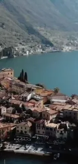 A scenic view of a vibrant village by a blue lake and mountain backdrop.