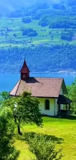 Lakeside chapel surrounded by lush greenery and hills.