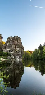 Scenic rock formations reflected in a tranquil lake under a clear blue sky.