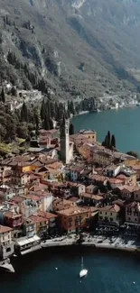 Aerial view of a lakeside village with colorful homes and mountain backdrop.