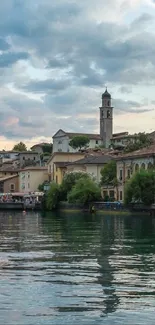 Scenic lakeside village with clock tower at dusk.