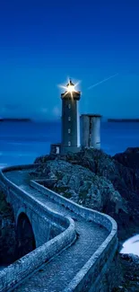 Lighthouse atop rocky coast with serene blue sea and sky.