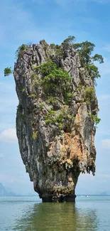 Majestic limestone island with lush foliage under a clear blue sky.