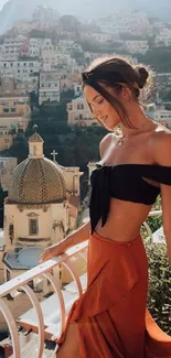 Elegant woman on balcony with Mediterranean backdrop.