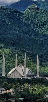 Lush green mountains with mosque in view.