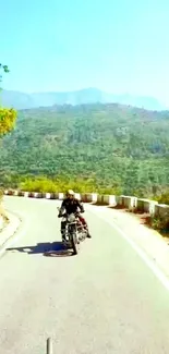 Motorcycle on a winding mountain road with lush greenery and blue skies.