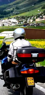 Motorcyclist on scenic road with mountains.