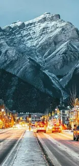 Snowy mountain town at night with glowing street lights.