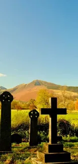 Mountainous graveyard with autumn colors and clear blue sky.