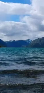 Scenic view of a tranquil mountain lake with blue water and cloudy sky.