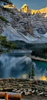 Mountain lake with forests and peaks under a blue sky.