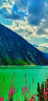 Mountain lake with vibrant flowers under a blue sky.