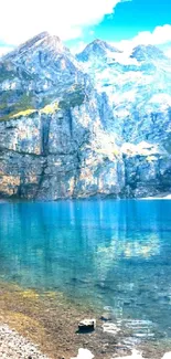 Mountain lake with clear blue water and rugged peaks in bright sunlight.