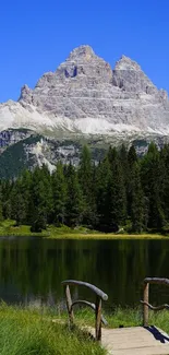 Scenic view of mountain, lake, and forest under a clear blue sky.