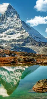 Mountain peak and lake reflection under clear blue sky.