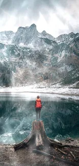 A person stands by a stunning mountain lake with reflected peaks.