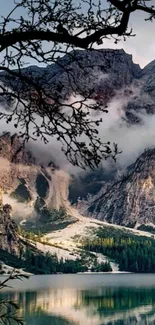 Calm mountain lake with misty peaks and serene forest.