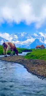 Mobile wallpaper of cows grazing by a river with a mountainous backdrop.