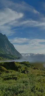 Scenic green mountain landscape with blue sky and clouds.