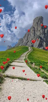 Scenic path with lush grass leading to a rocky mountain under a vibrant blue sky.