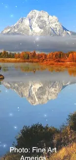 Snow-capped mountain reflecting in a serene lake with autumn colors.