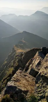 Scenic view from a mountain ridge with hills in the background.