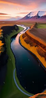 Serene river flowing through orange-lit mountains at sunset with snow-capped peaks.