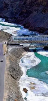 Scenic view of a mountain river with a bridge and road.