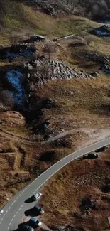 Aerial view of a scenic mountain road with surrounding landscapes.