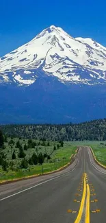 A scenic road leading to snowy mountains under a clear blue sky.