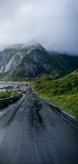 Scenic road through misty mountains with lush green landscape.