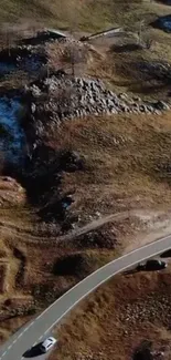 Scenic view of a winding mountain road with rocky terrain.