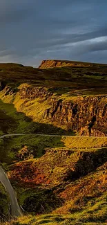 Winding mountain road under dramatic sky wallpaper.