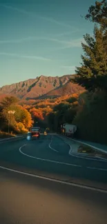 Winding road through mountains with autumn foliage.